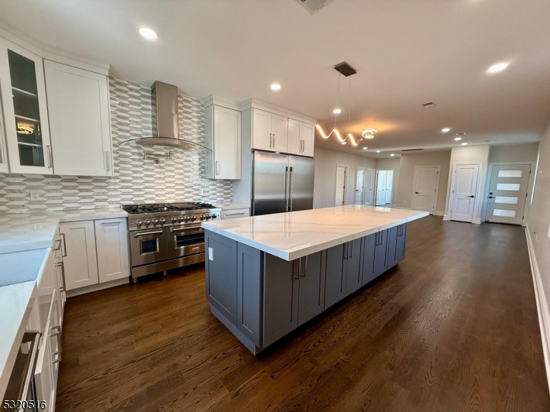 a large kitchen with a large counter top and stainless steel appliances