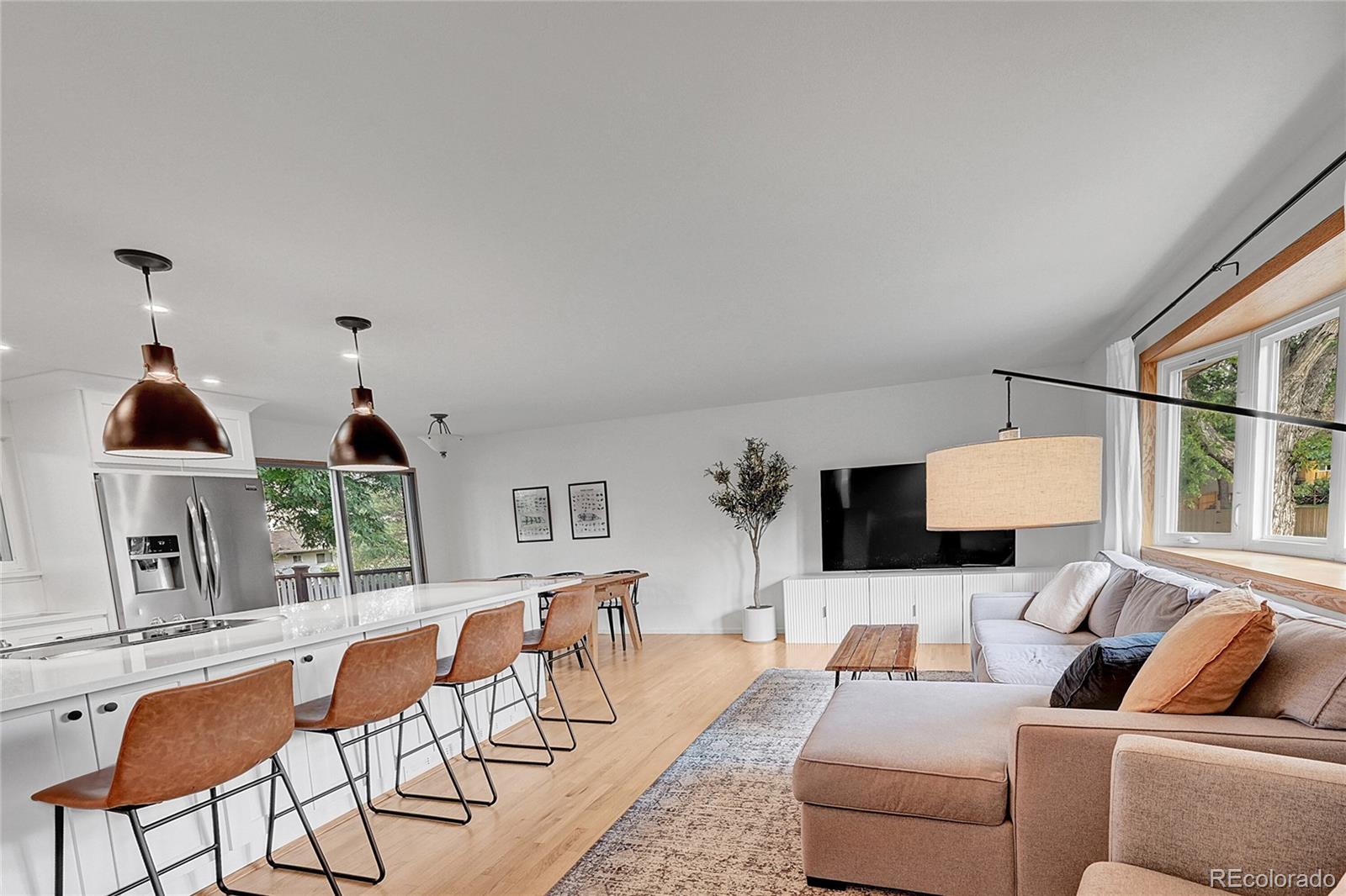 a living room with furniture a window and a flat screen tv