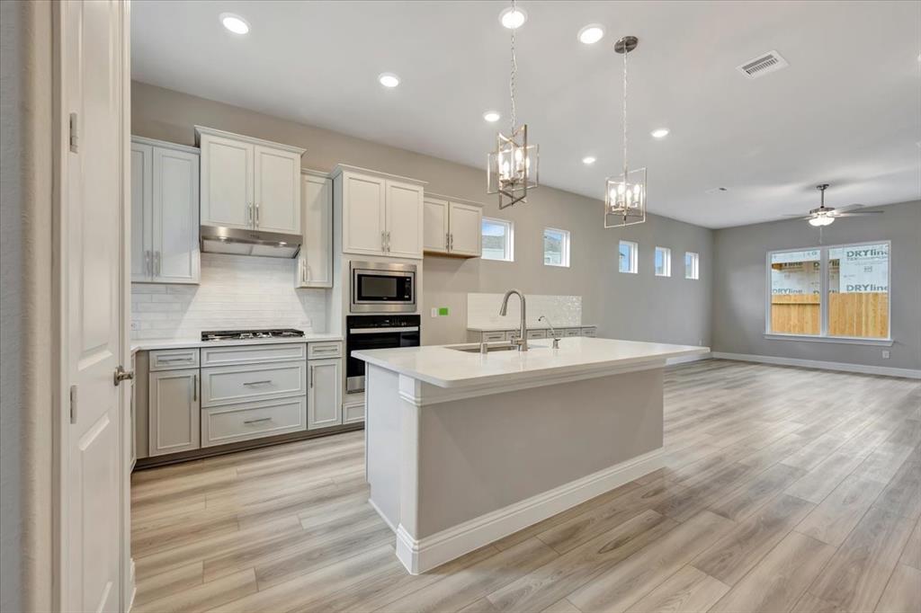 a kitchen with stainless steel appliances kitchen island granite countertop a stove and a sink