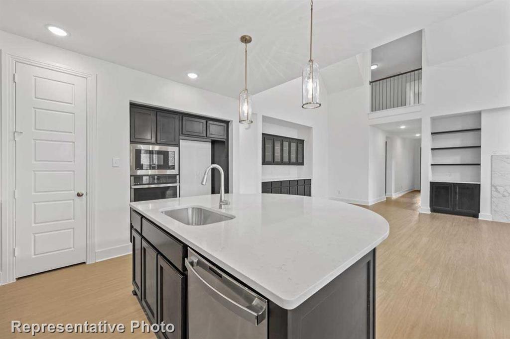 a kitchen with kitchen island a sink appliances and a counter top space