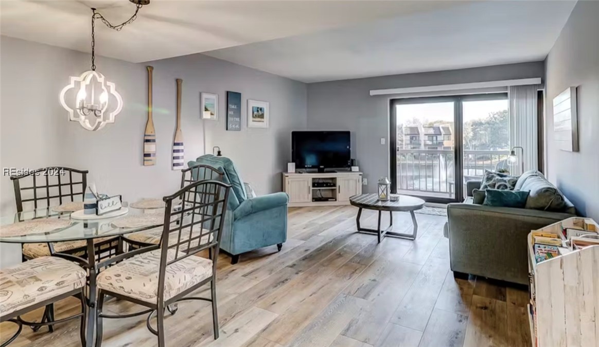 Living room with light LVT flooring and a chandeli