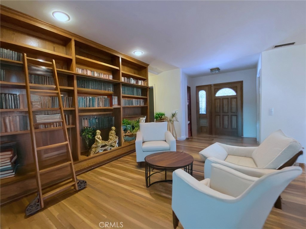 a living room with furniture a bookshelf and a window