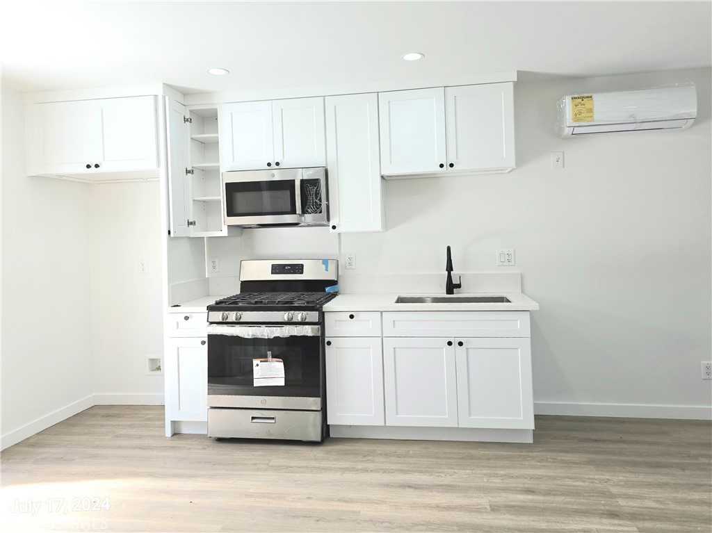 a kitchen with cabinets stainless steel appliances and wooden floor