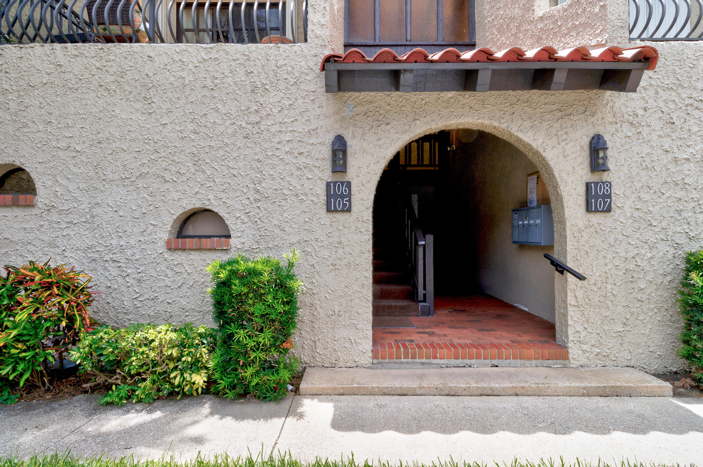 a front view of a house with plants