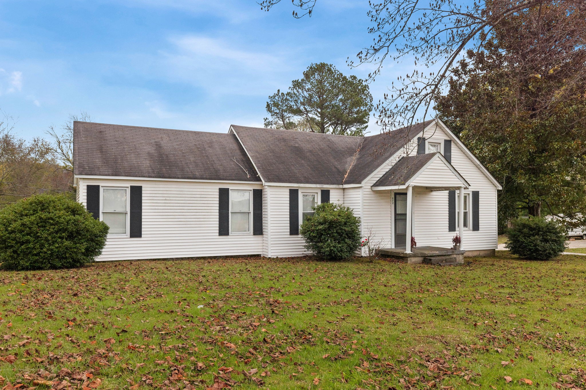 a front view of house with yard and trees in the background