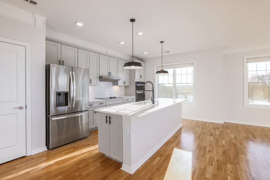 a kitchen with kitchen island a sink stainless steel appliances and window