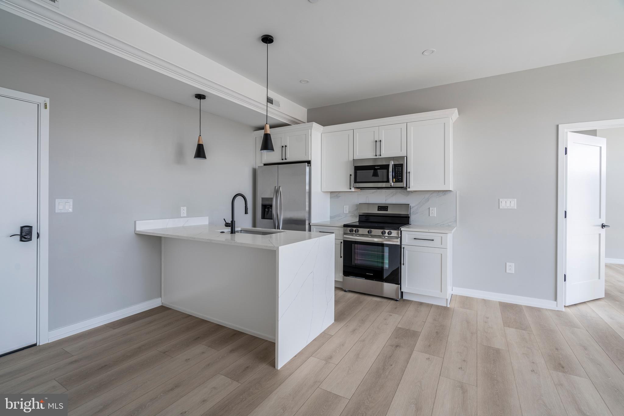 a kitchen with granite countertop a sink and steel appliances