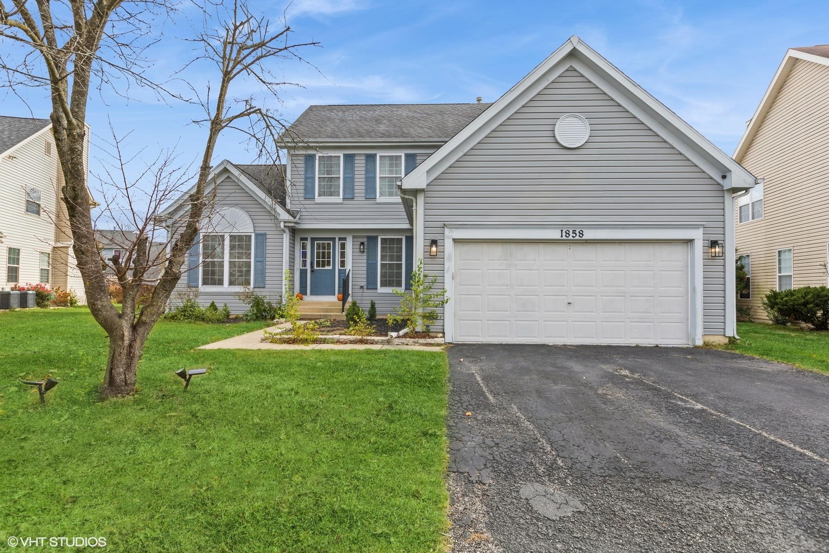 a front view of a house with yard and green space