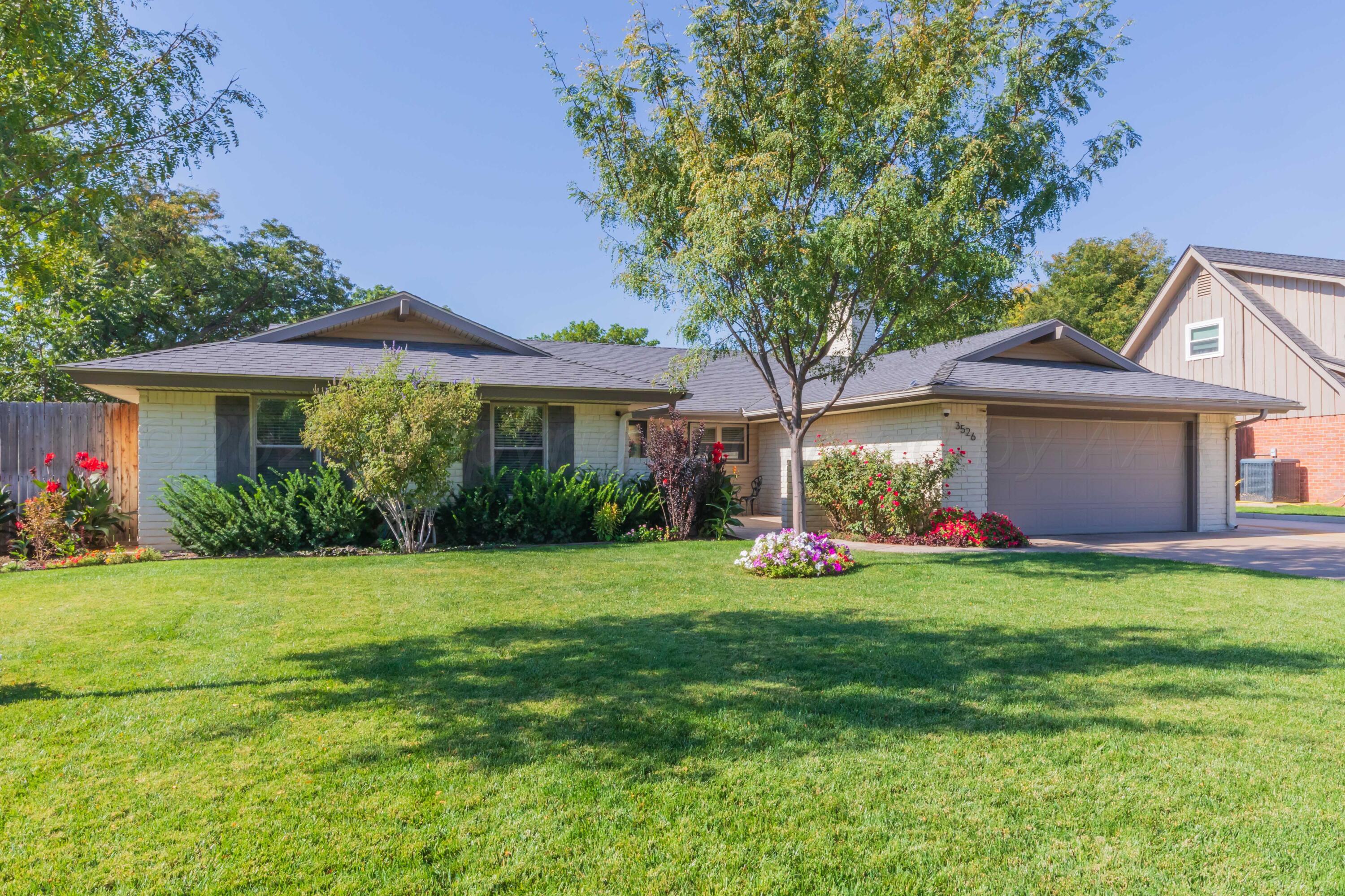 a front view of a house with a garden and trees