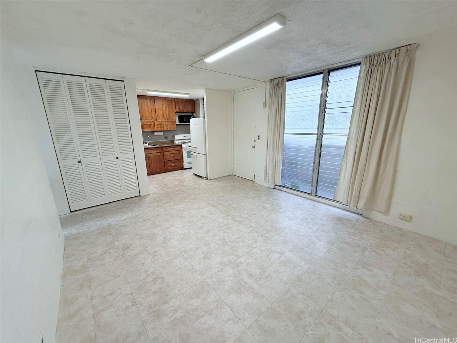 an empty room with windows and cabinet