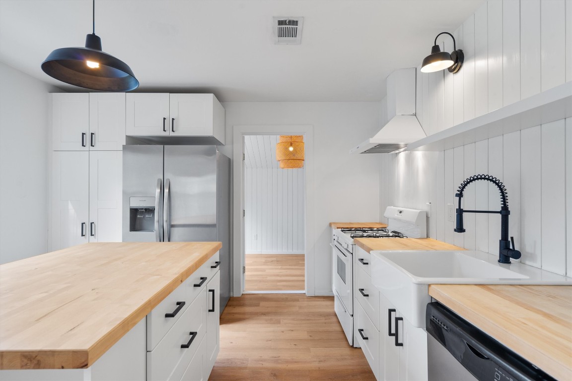 a kitchen with stainless steel appliances a sink a stove and refrigerator