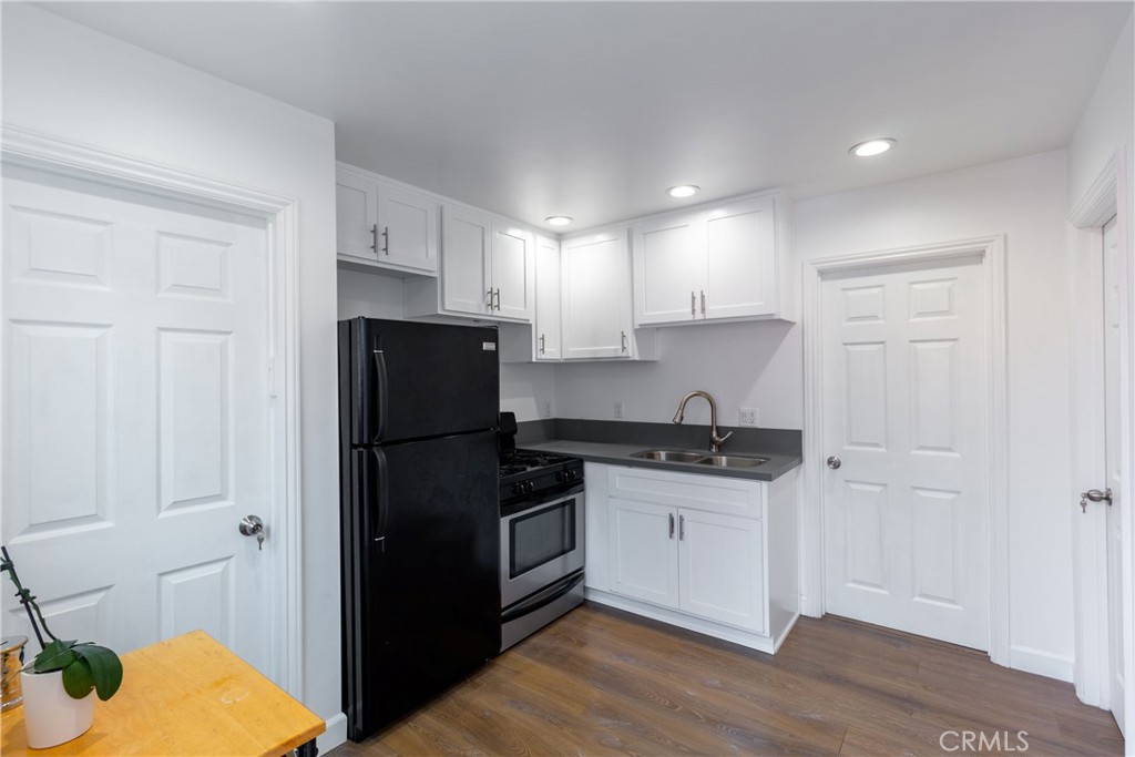 a kitchen with a sink a refrigerator and cabinets