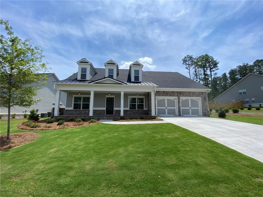 a front view of house with yard barbeque and outdoor seating