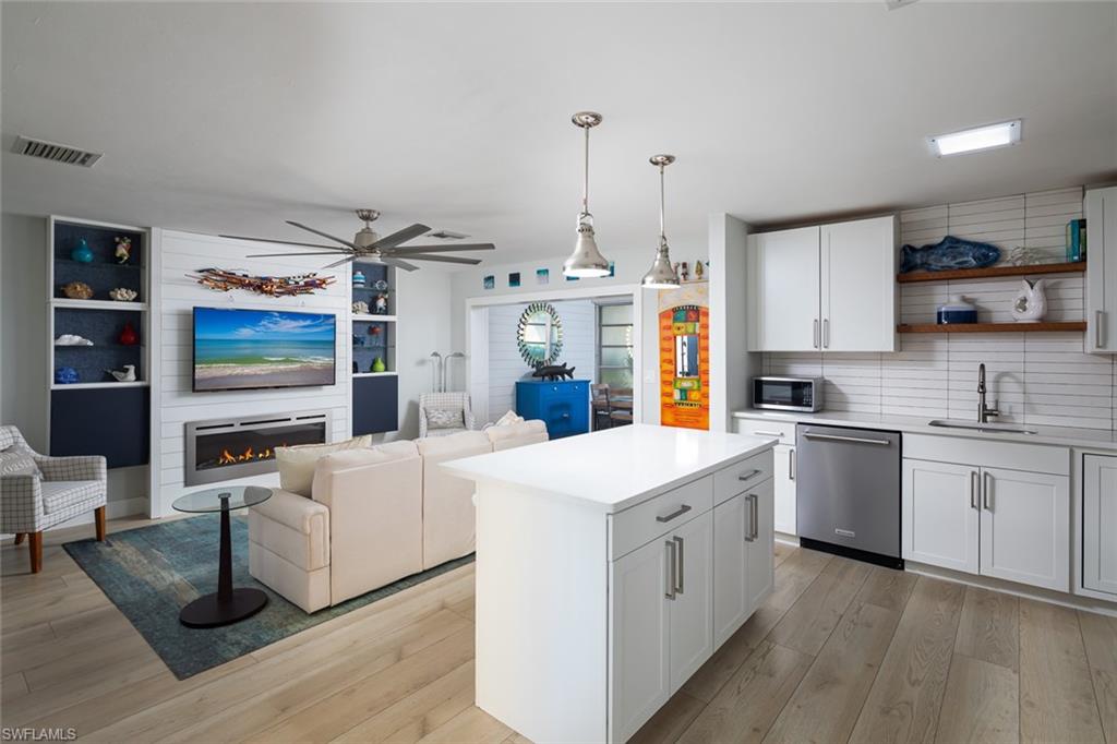 a kitchen that has a lot of cabinets in it and wooden floors