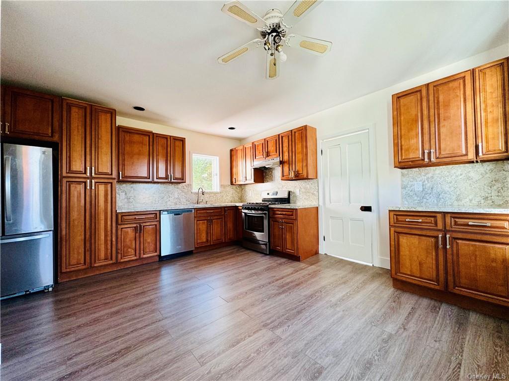 a kitchen with stainless steel appliances a refrigerator and a stove top oven