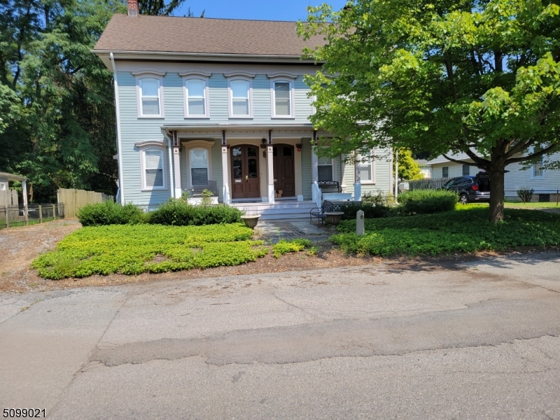 a front view of a house with a yard and potted plants