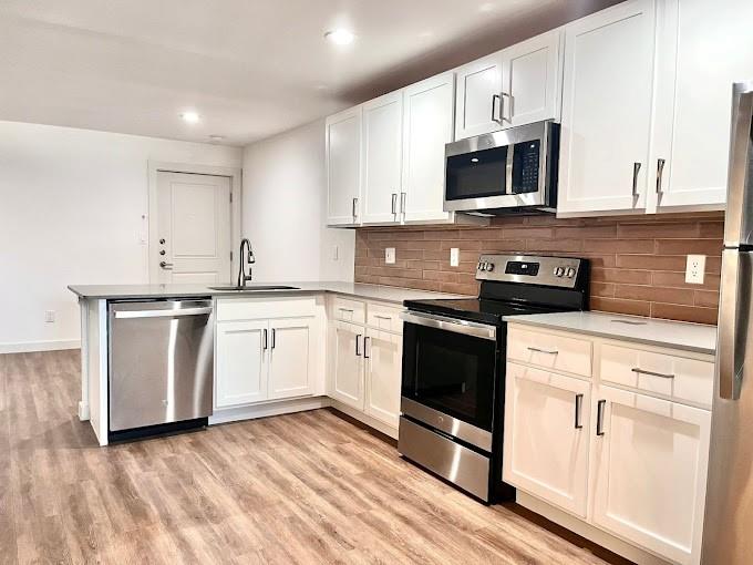 a white kitchen with granite countertop stainless steel appliances