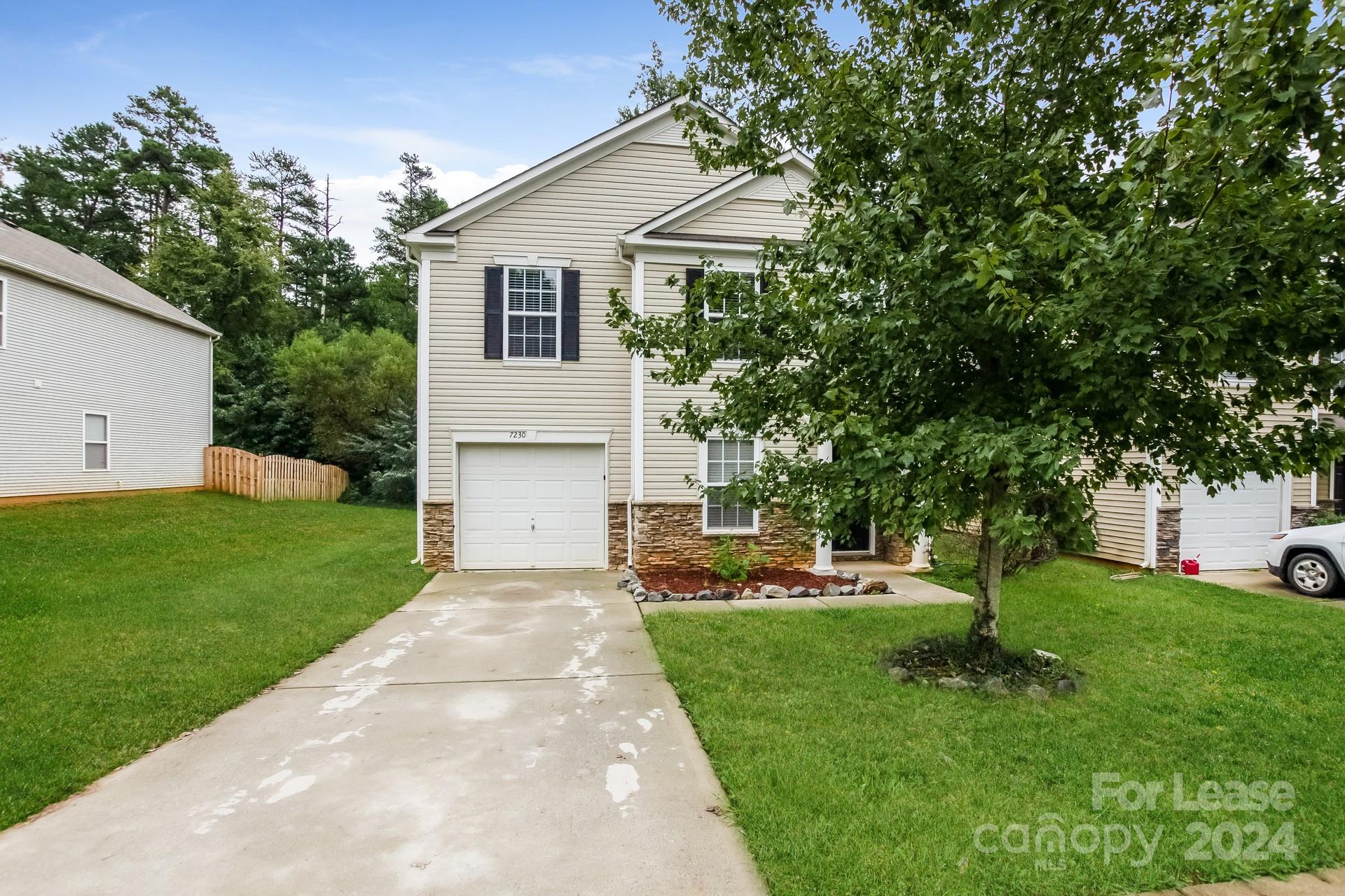 a front view of a house with a yard and trees