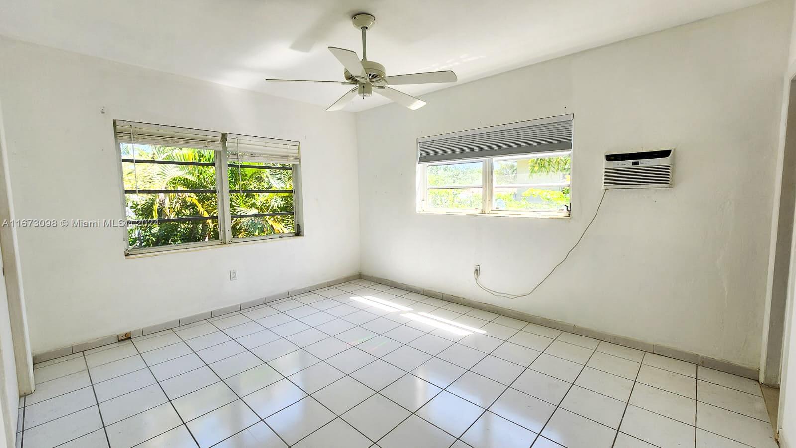 an empty room with windows and closet