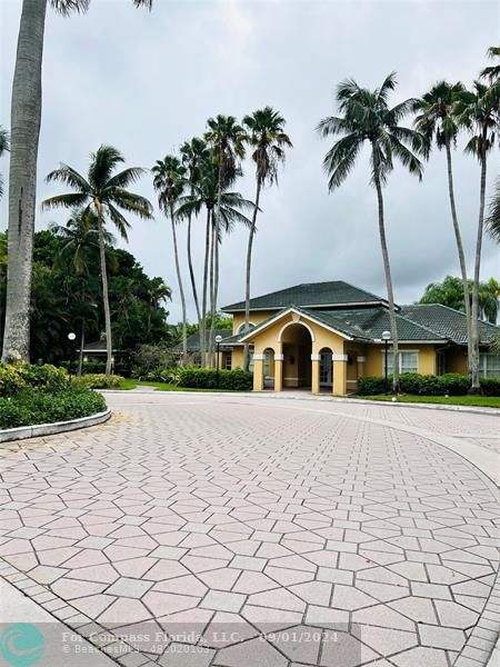 a front view of a house with a yard and palm trees