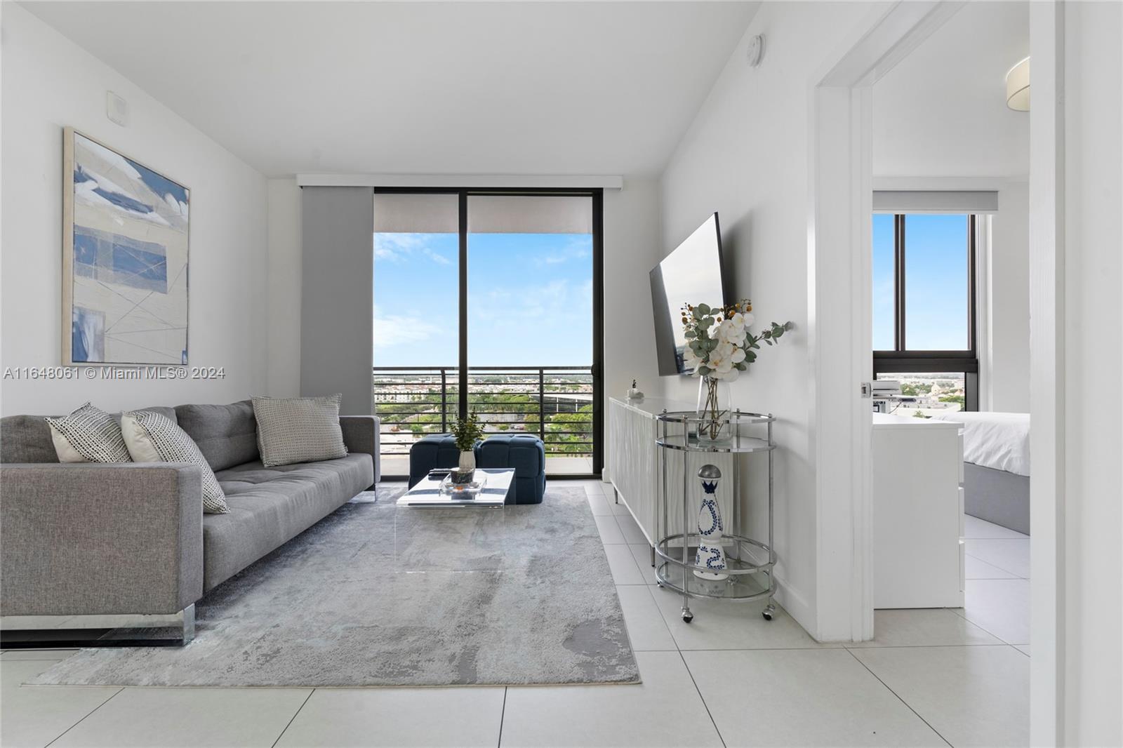 a living room with furniture large window and table