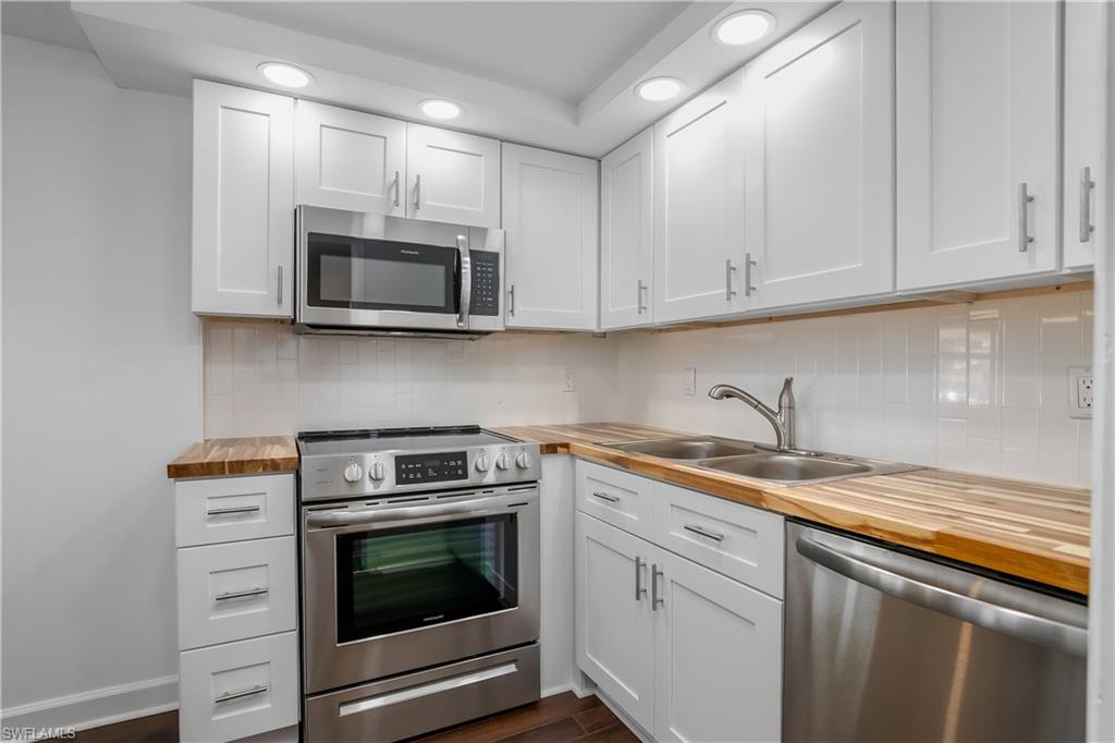 a kitchen with granite countertop white cabinets and stainless steel appliances