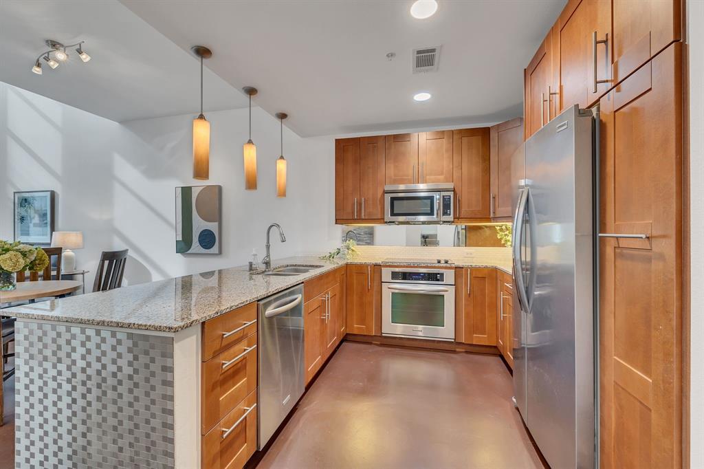 a kitchen with stainless steel appliances a refrigerator sink and microwave