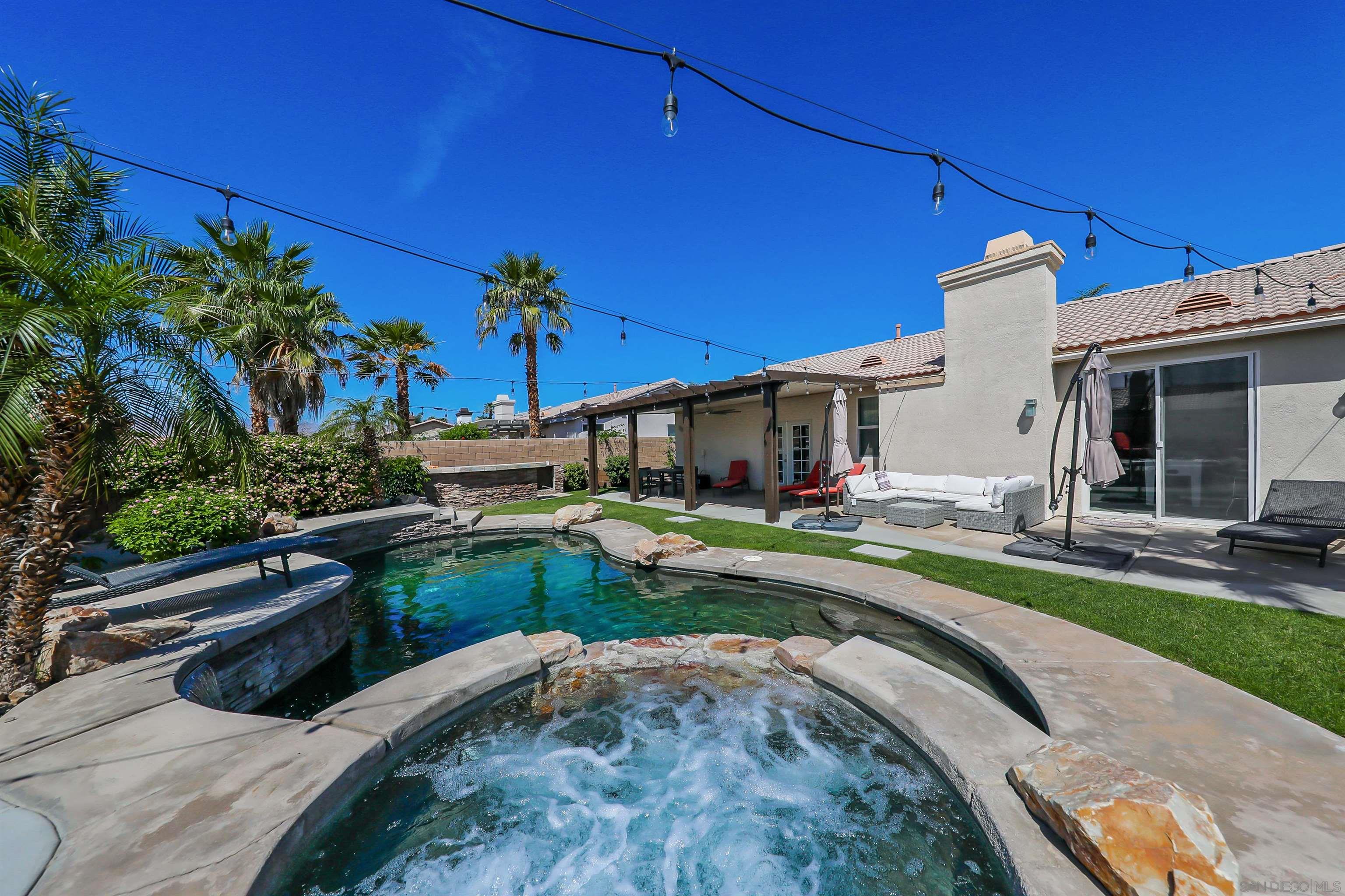 a view of a house with pool and chairs