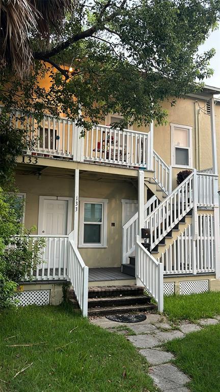 a view of a house with a small yard and wooden fence