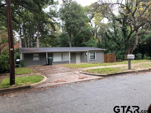 a view of a house with a yard and large tree