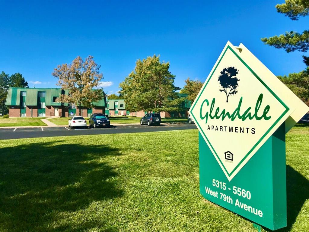 a sign that is sitting in the grass with plants