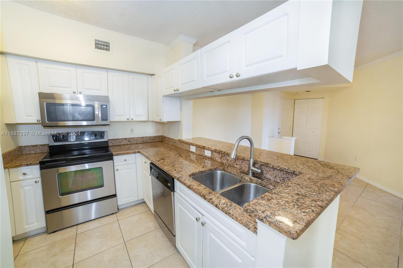 a kitchen with stainless steel appliances granite countertop a sink a stove and a microwave