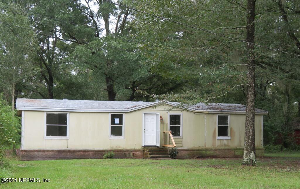 a view of a house with yard and sitting area