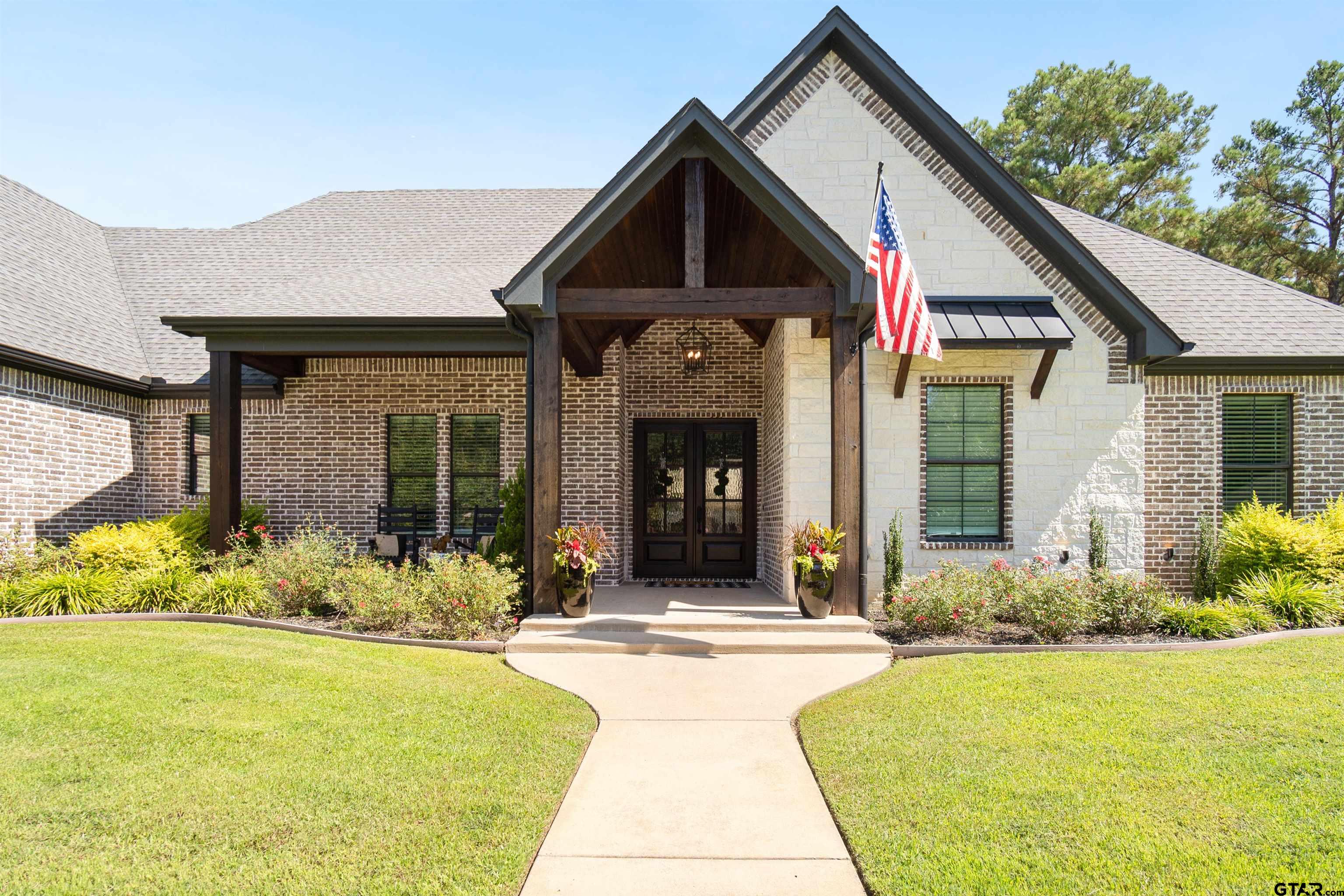 a front view of a house with a yard and outdoor seating