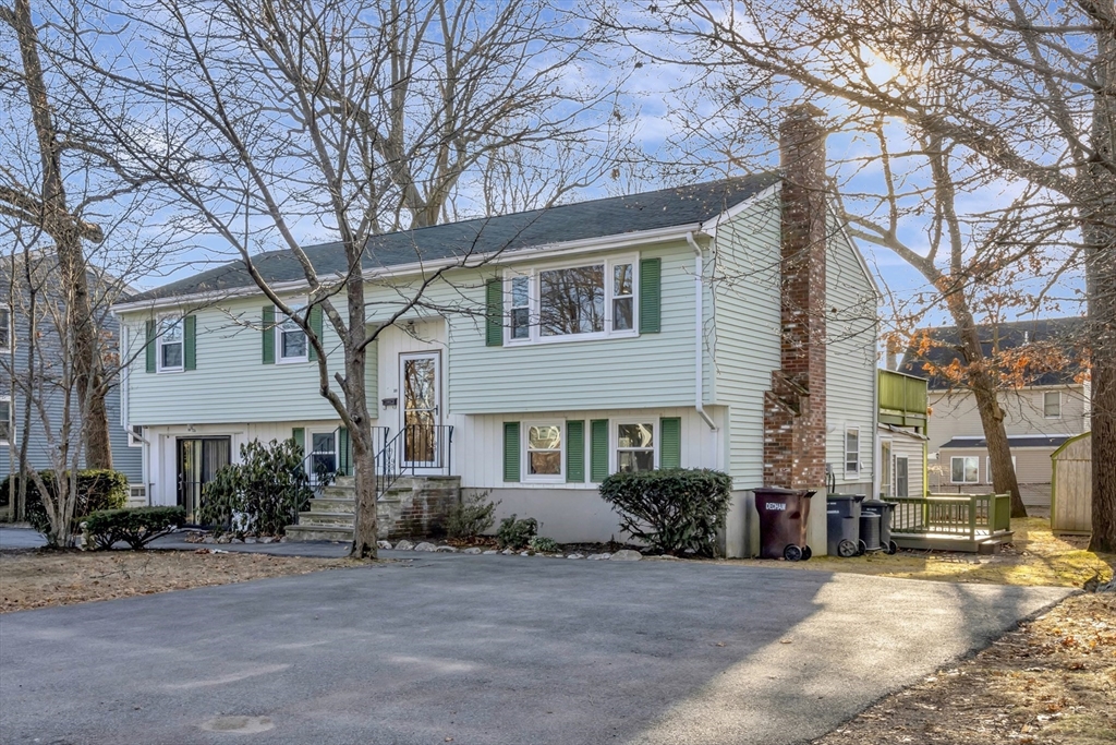 a front view of a house with a tree in front