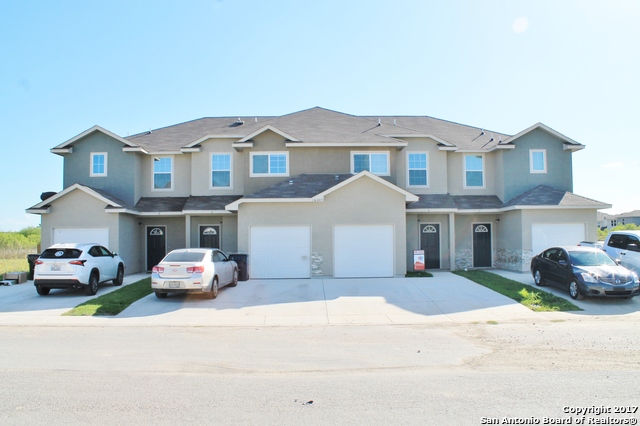 a front view of a house with a parking space