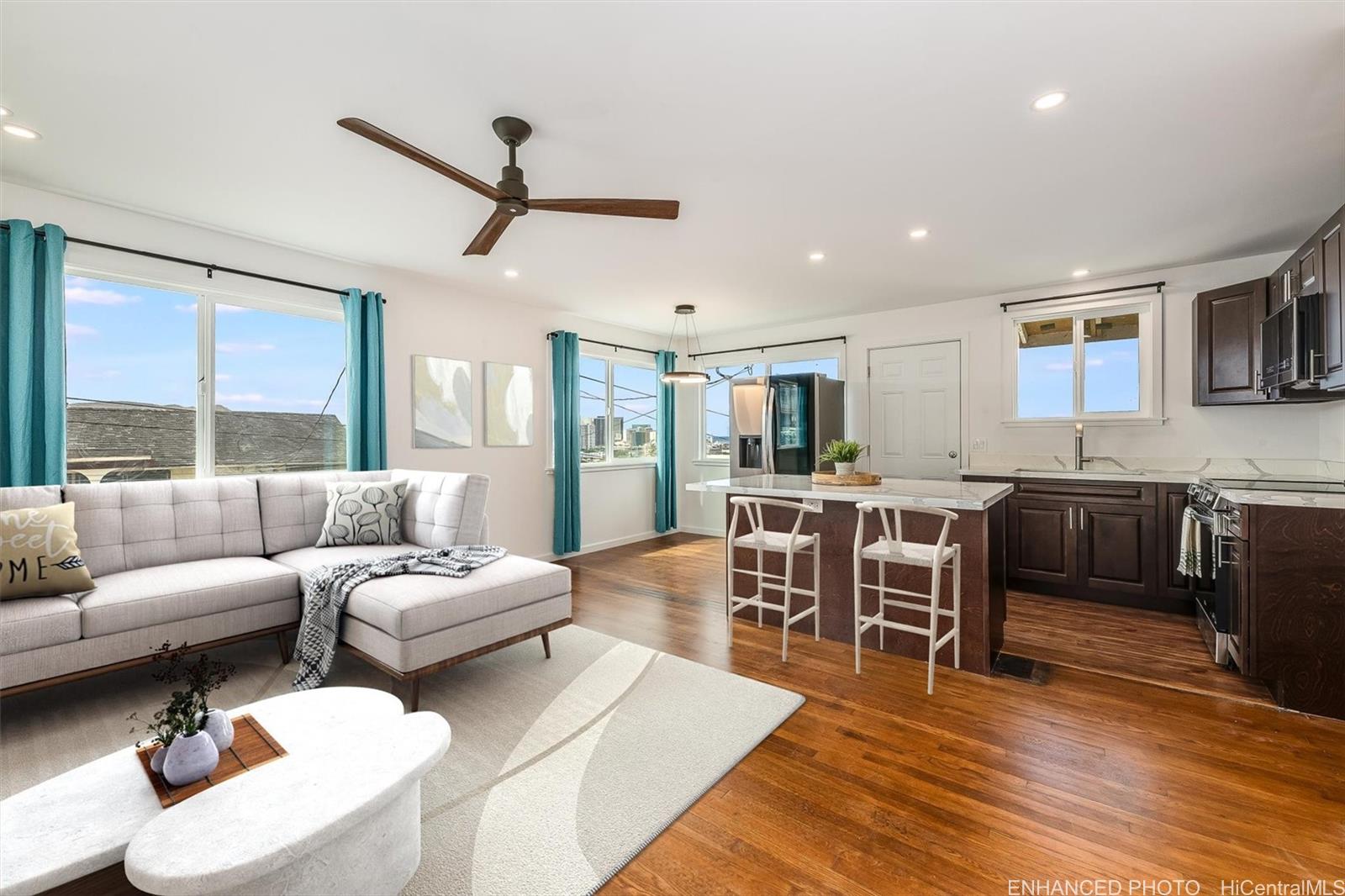 a living room with furniture kitchen view and a large window