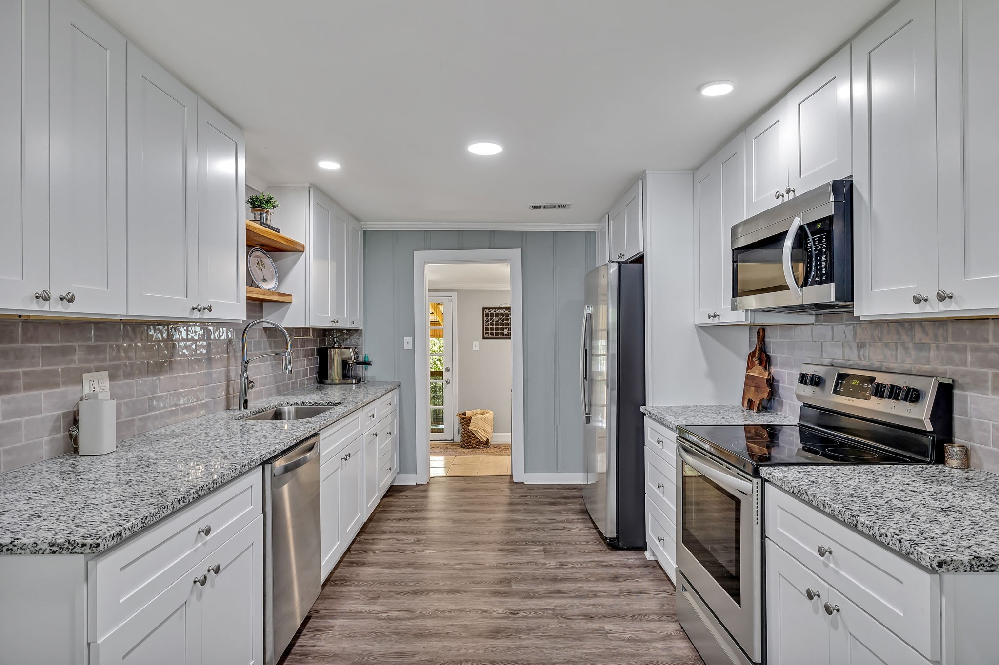 a kitchen with stainless steel appliances granite countertop wooden cabinets granite counter tops and a hard wood floors