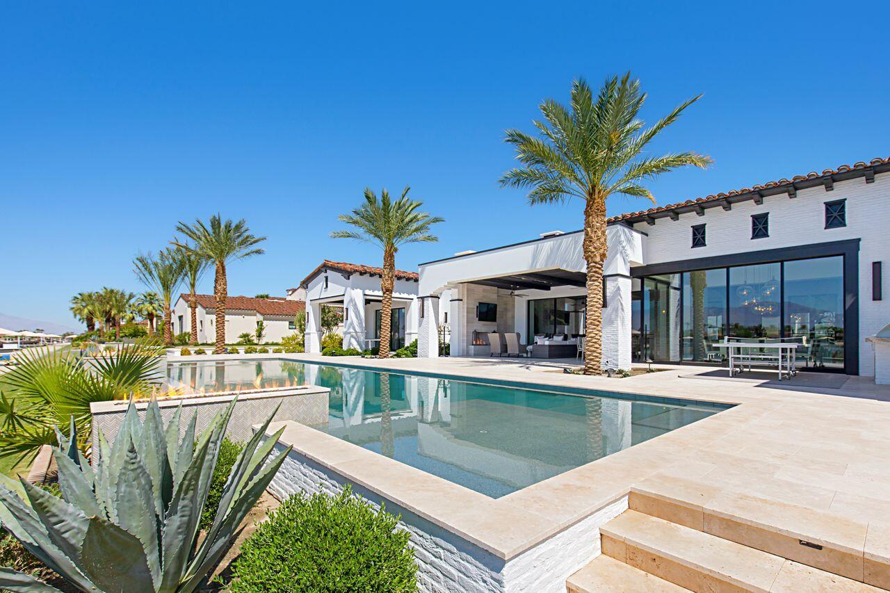 a view of a house with pool and chairs