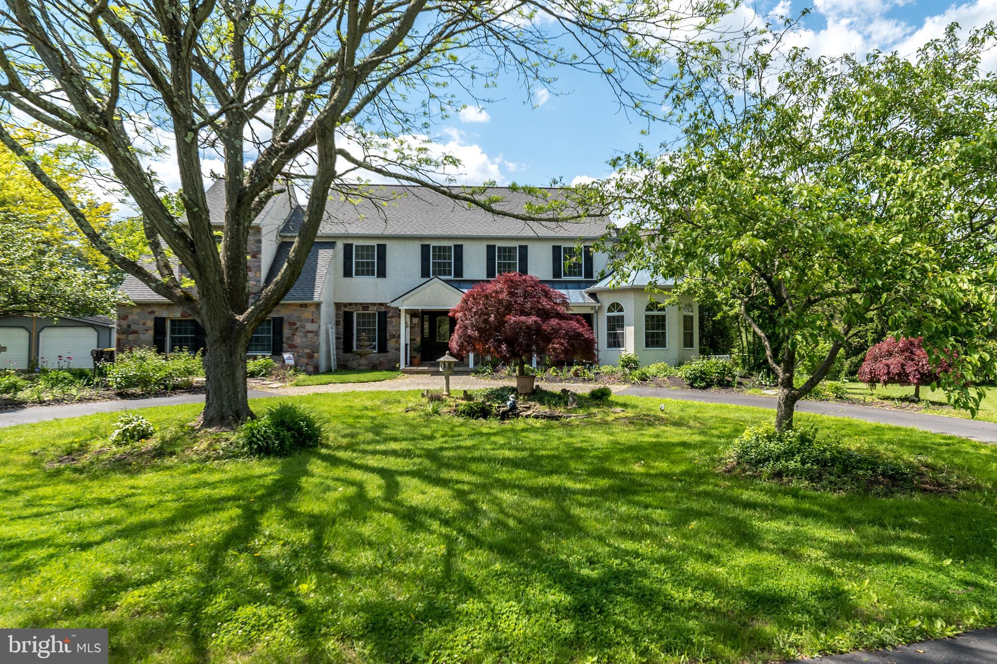 a front view of a house with yard and green space