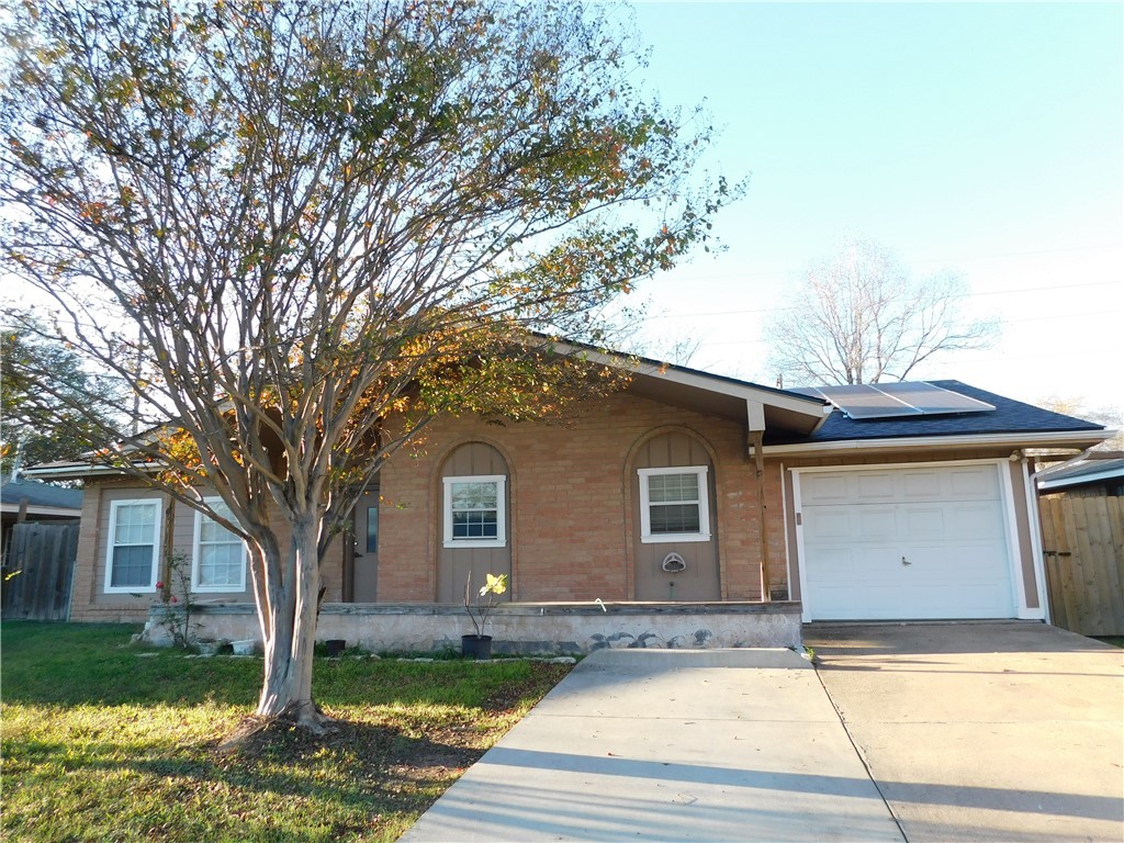 Ranch-style home featuring a front yard, a garage,