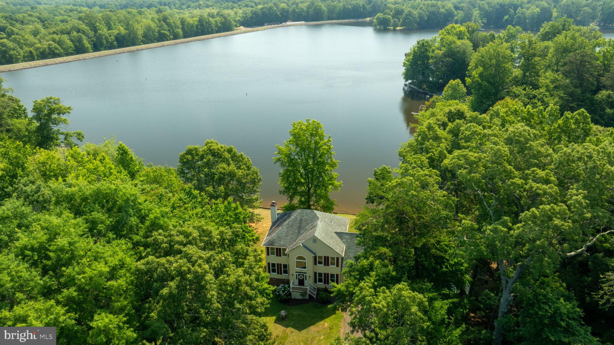 an aerial view of a house with a yard and lake view