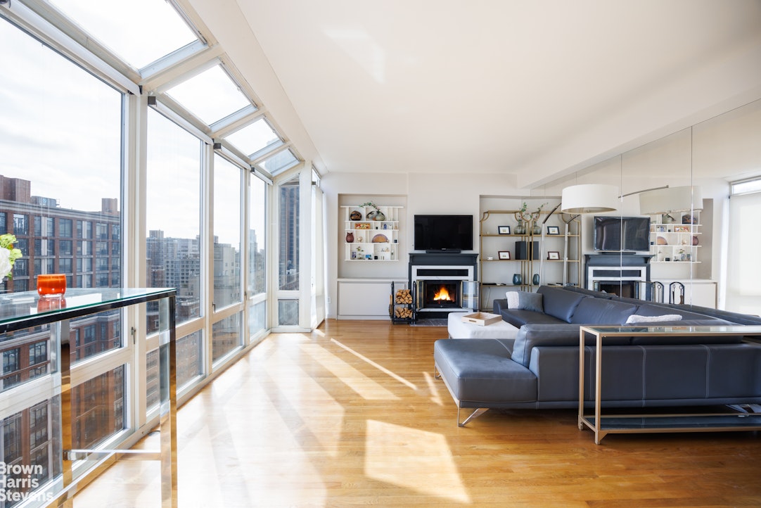 a living room with furniture a flat screen tv and a floor to ceiling window