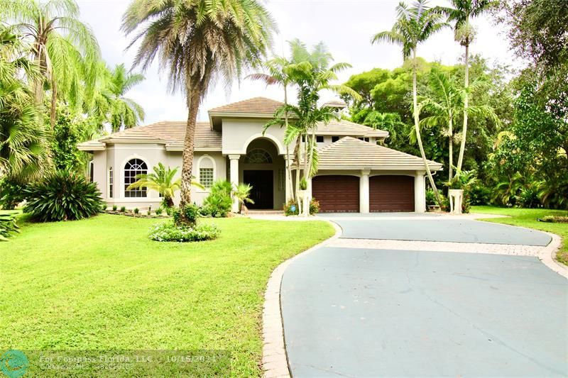 a front view of a house with yard and green space