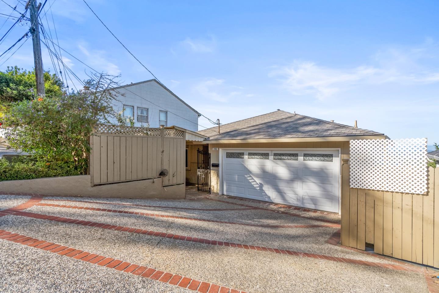 a view of a house with a small yard and wooden fence