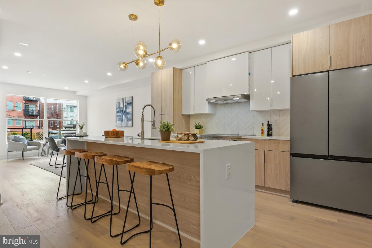 a kitchen with a refrigerator a sink and chairs