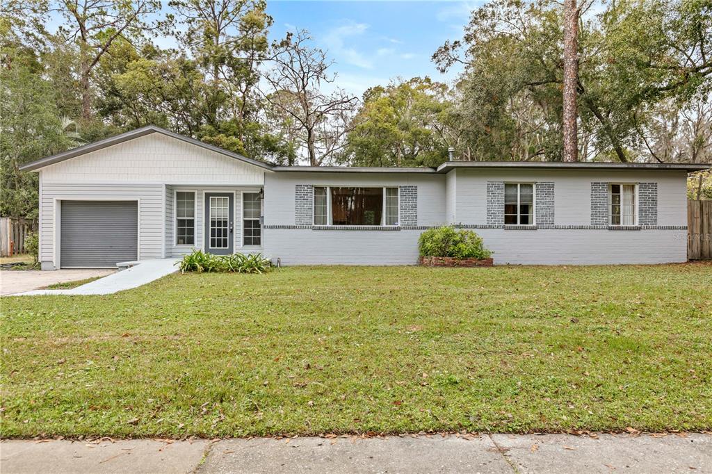 a front view of house with yard and trees around