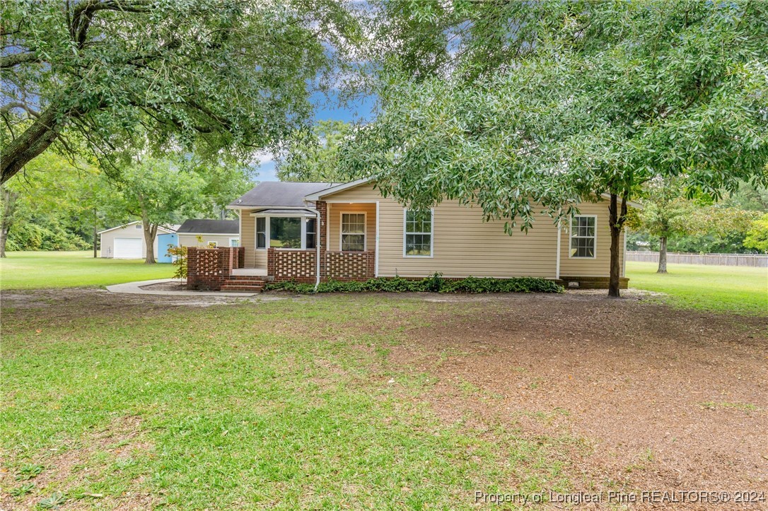 a front view of house with yard and trees