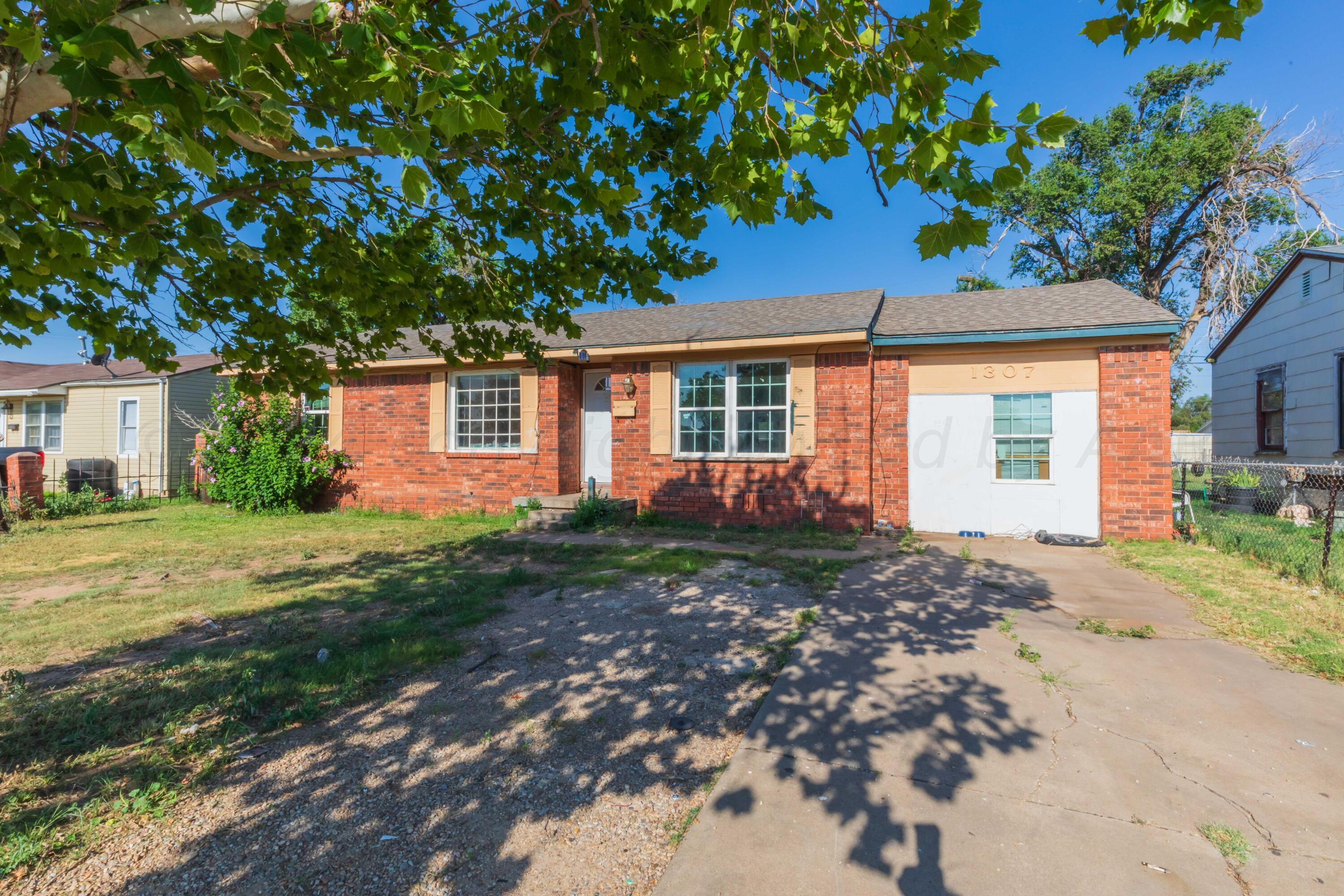 a view of a house with backyard and a tree