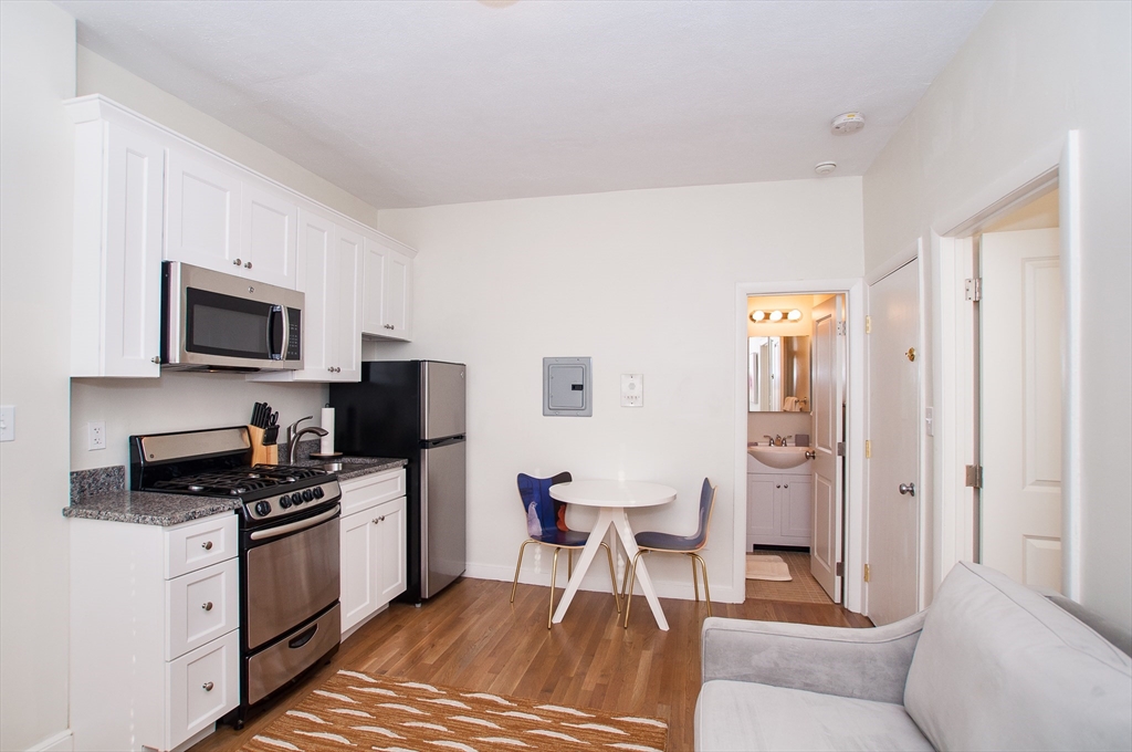 a kitchen with a refrigerator and a stove top oven